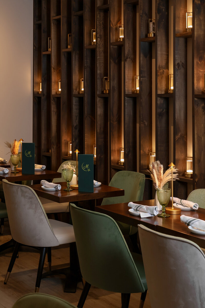 Dining room with multiple set tables with flower and light decorations