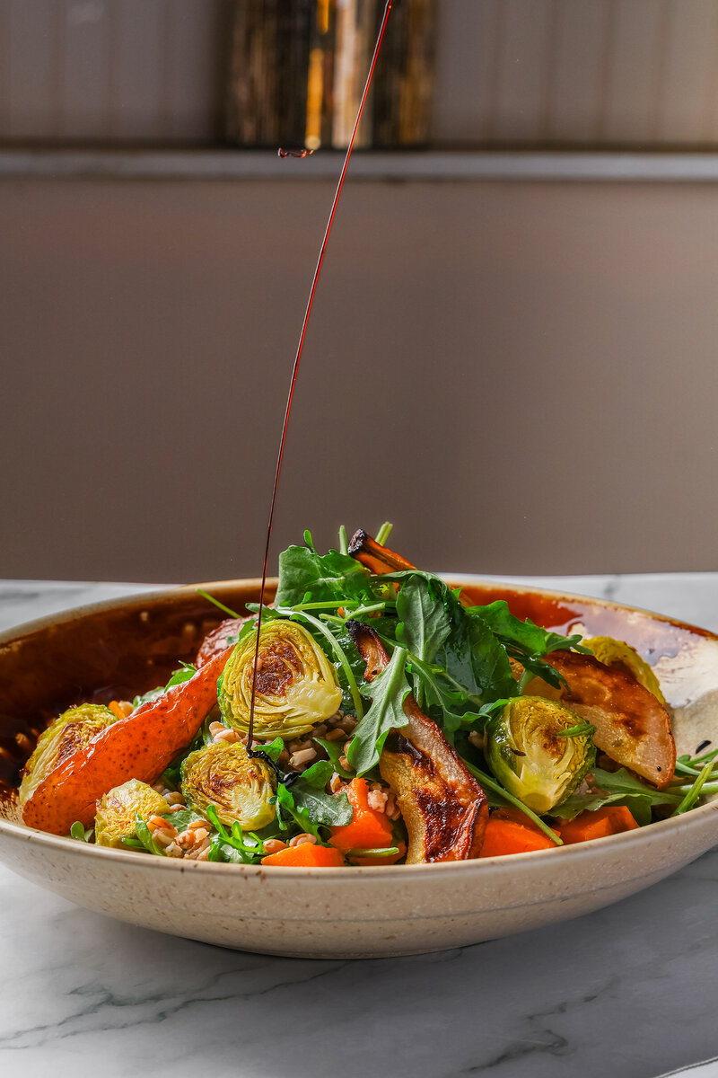 Balsamic dressing being poured onto salad